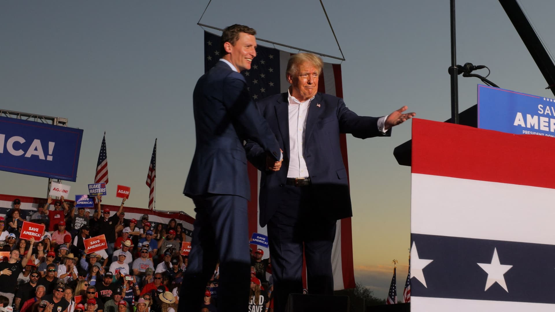Former U.S. President Donald Trump shakes hands with U.S. Senate candidate Blake Masters (R-AZ) on stage during a rally ahead of the midterm elections, in Mesa, Arizona, October 9, 2022.