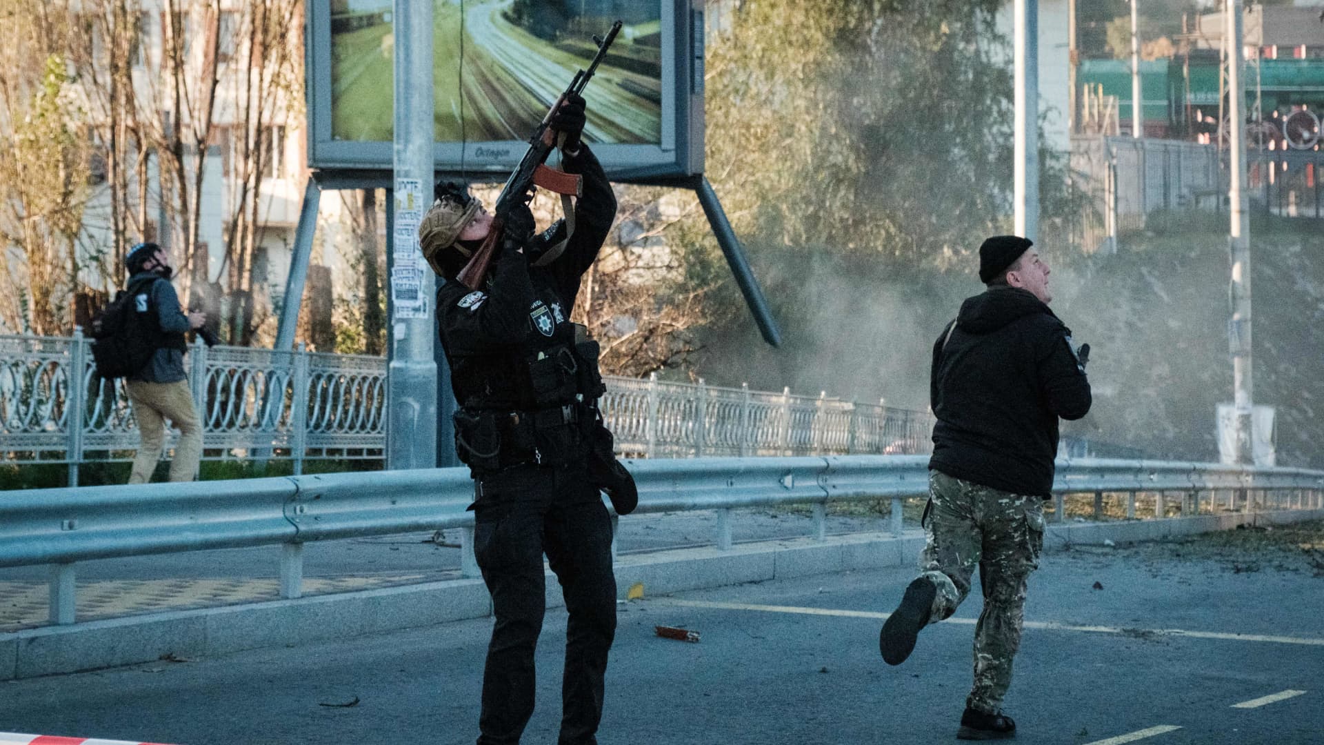 A police officer fires at a flying drone following attacks in Kyiv on October 17, 2022.