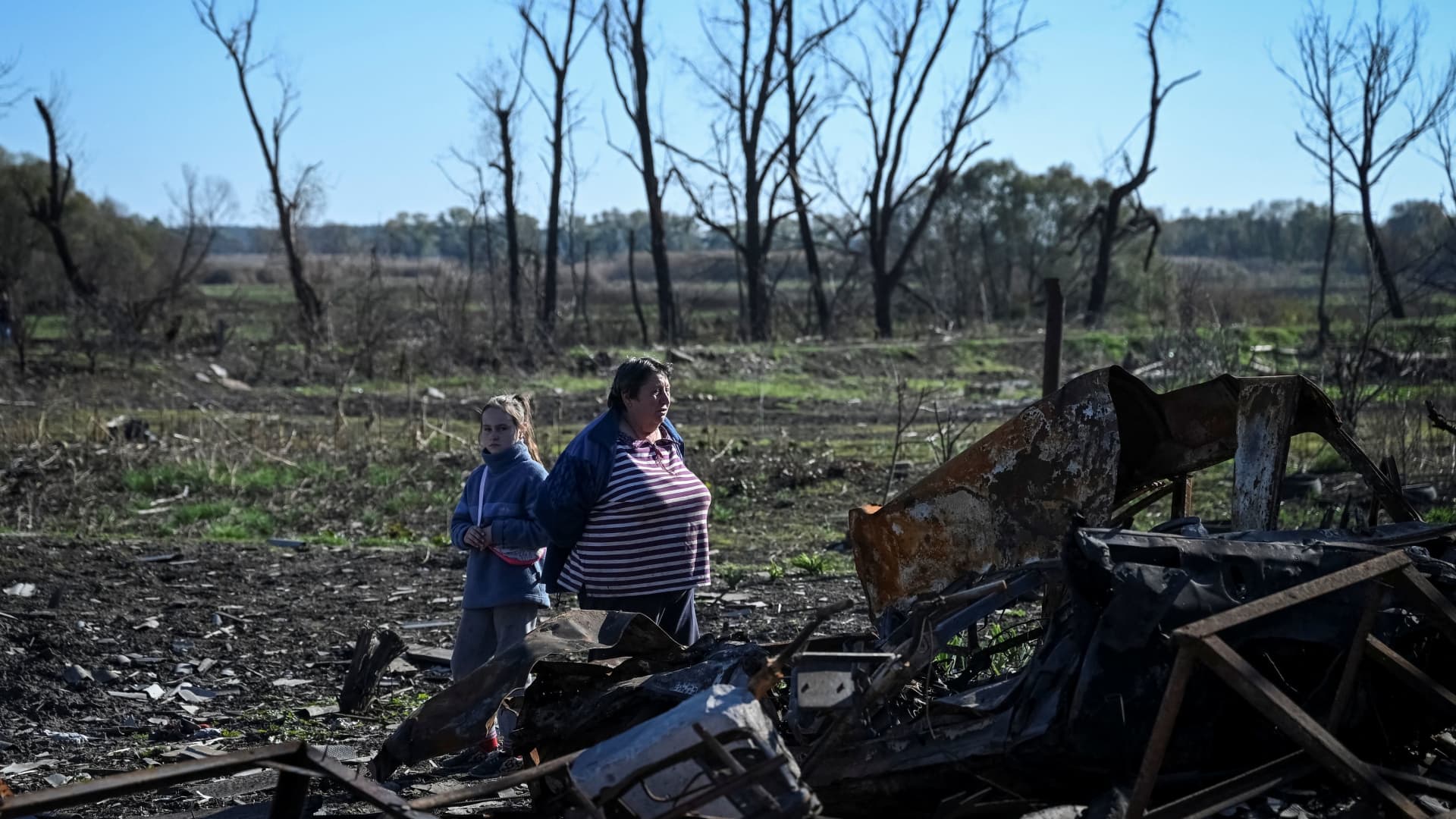 Local residents Natalia, 59, and her granddaughter Ilona, 9, stand on ruins of their house, amid Russia's attack on Ukraine, in Kupiansk Vuzlovyi, Ukraine October 17, 2022.