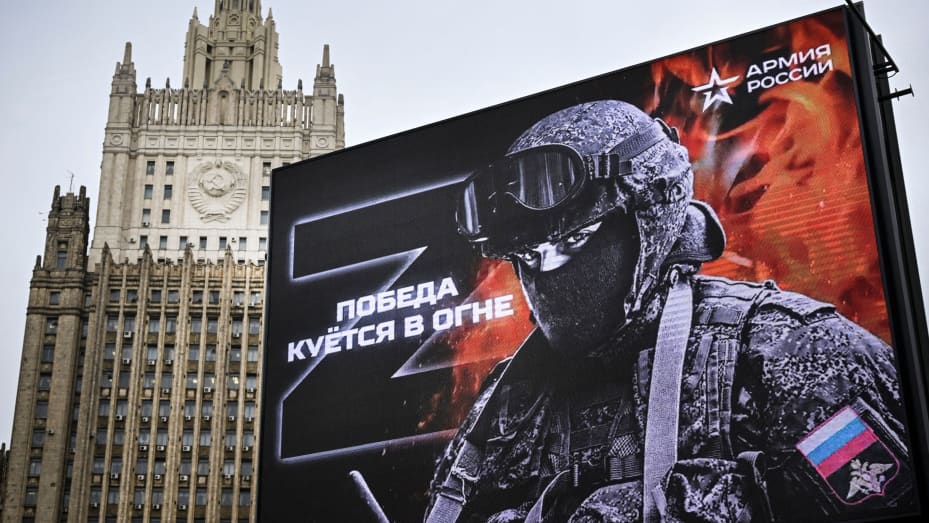 TOPSHOT - Russian Foreign Ministry building is seen behind a social advertisement billboard showing Z letters - a tactical insignia of Russian troops in Ukraine and reading "Victory is being Forged in Fire" in central Moscow on October 13, 2022. - Five Russians drafted to fight in Ukraine, as part of the "partial" mobilization ordered in September, died after joining the army, authorities said, as similar announcements have multiplied in recent days. (Photo by Alexander NEMENOV / AFP) (Photo by ALEXANDER NE