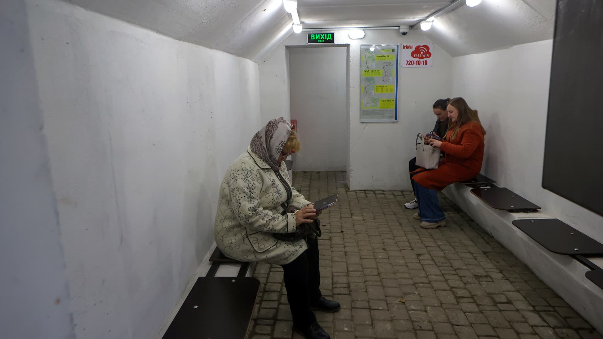 People sit inside a concrete bomb shelter set next to one of the bus stops during an air alert, Kharkiv, norheastern Ukraine. 