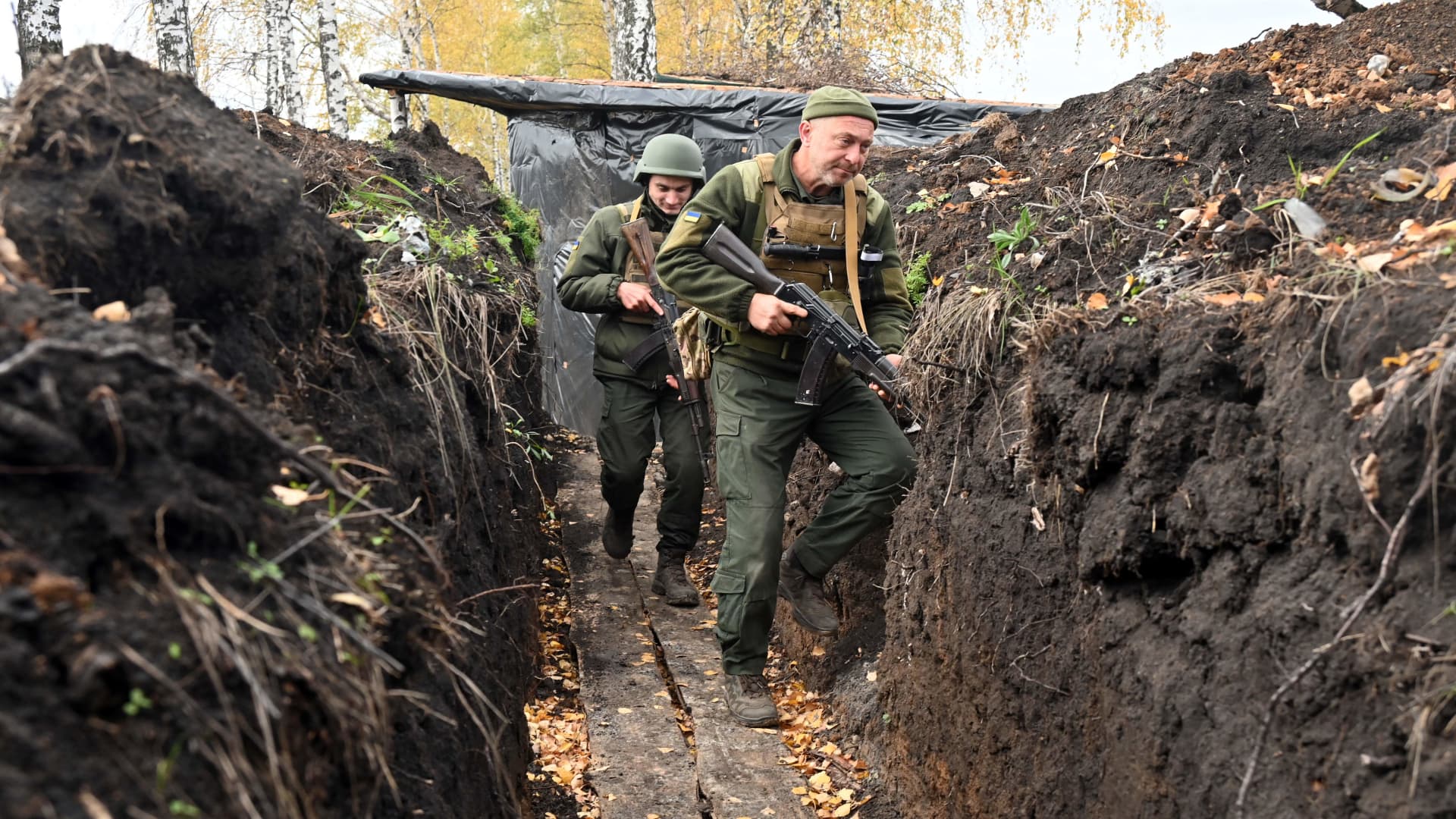 Soldiers of the National Guard of Ukraine walk along a trench towards their positions on the northern occupied territories of Kharkiv region on October 21, 2022, amid the Russian military invasion of Ukraine.