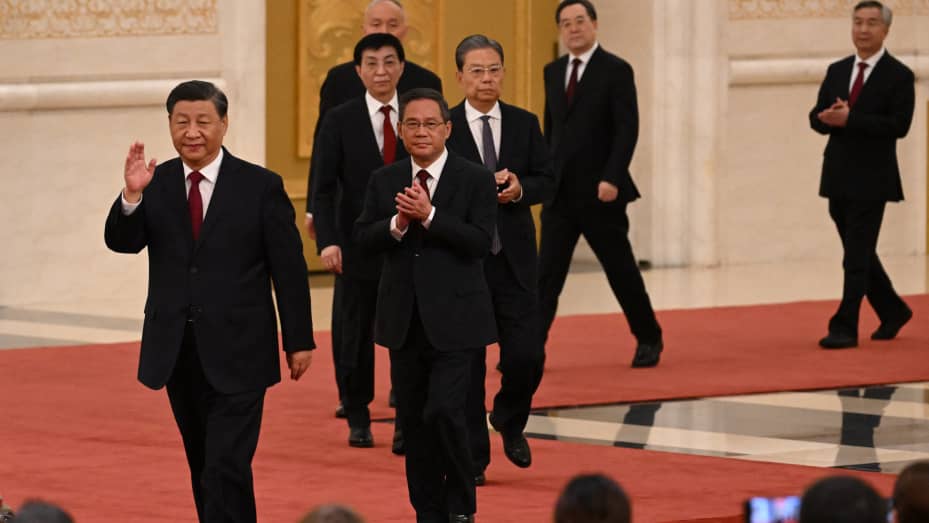 China's President Xi Jinping (L) walks with members of the Chinese Communist Party's new Politburo Standing Committee, the nation's top decision-making body, as they meet the media in the Great Hall of the People in Beijing on Oct. 23, 2022.