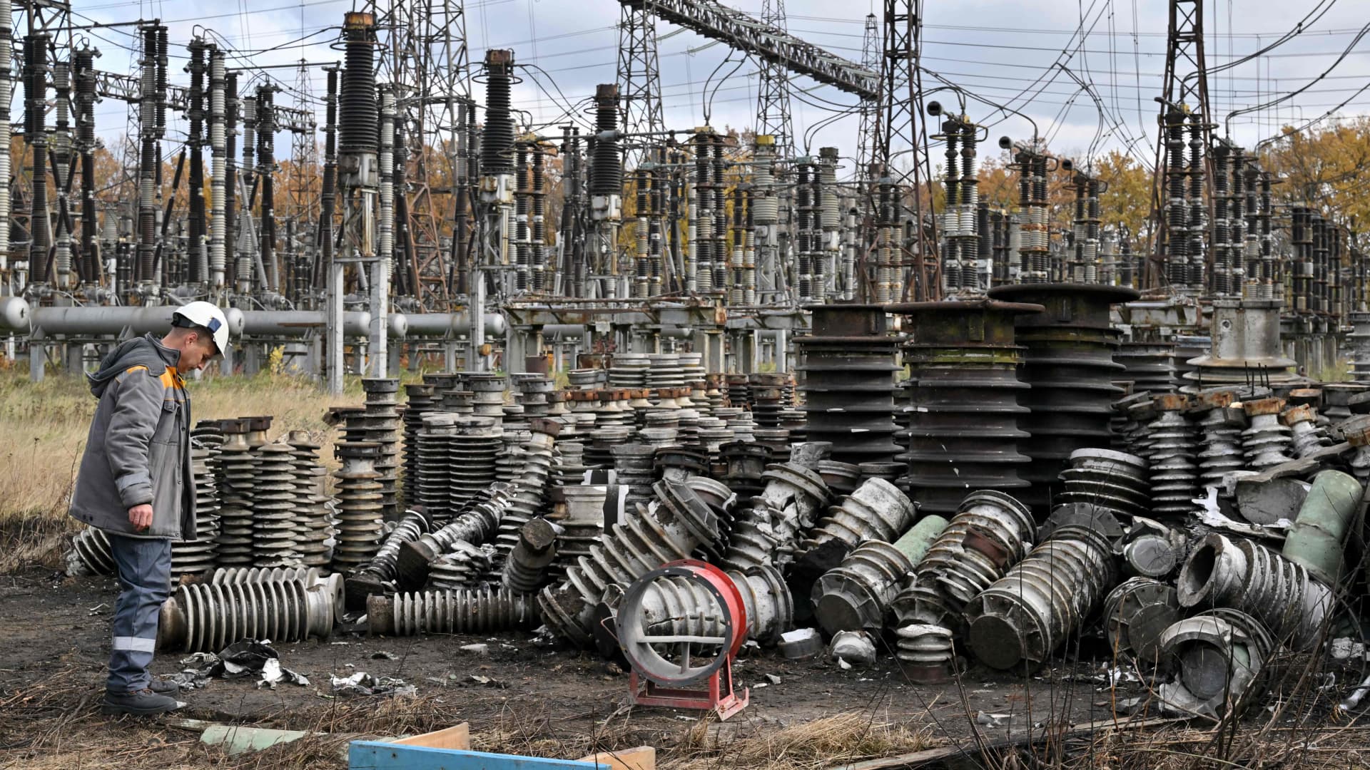 A worker examines damage as he repairs power line equipment destroyed after a missile strike on a power plant, in an undisclosed location of Ukraine, on Oct. 27, 2022.