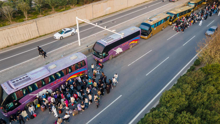 Foxconn employees take shuttle buses to head home on October 30, 2022 in Zhengzhou, Henan Province of China.
