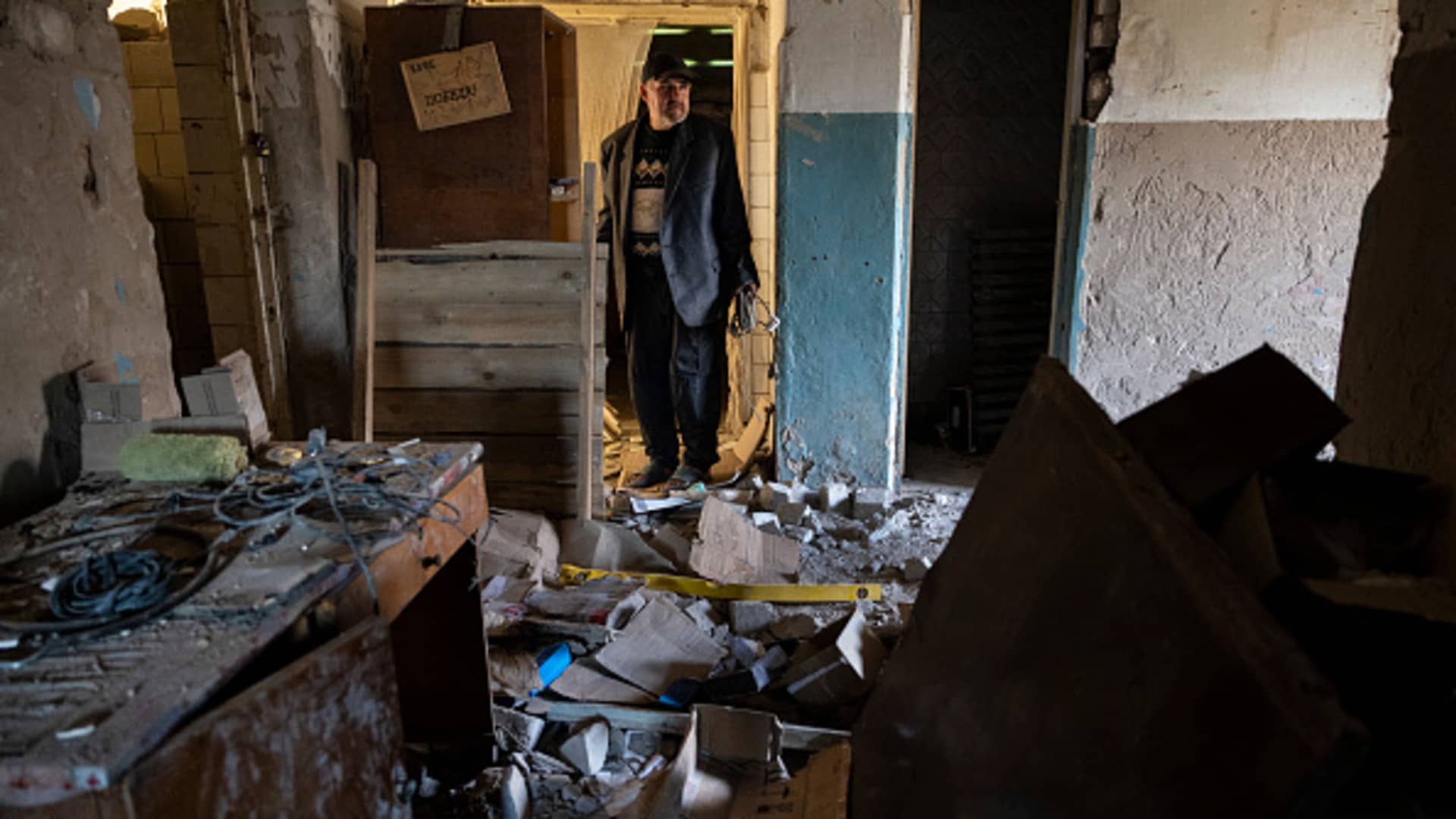 A man who claims to be a former prisoner, tortured with electric shocks by the Russian military, checks the debris inside a destroyed Russian command center on September 29, 2022 in Izium, Ukraine. On September 9th, Ukrainian armed forces hit the center that was known as a jail and torture chamber.