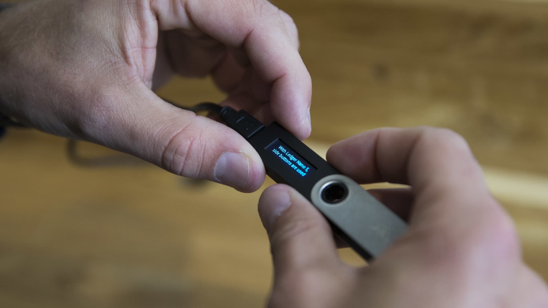 A person holds a cryptocurrency hardware wallet.