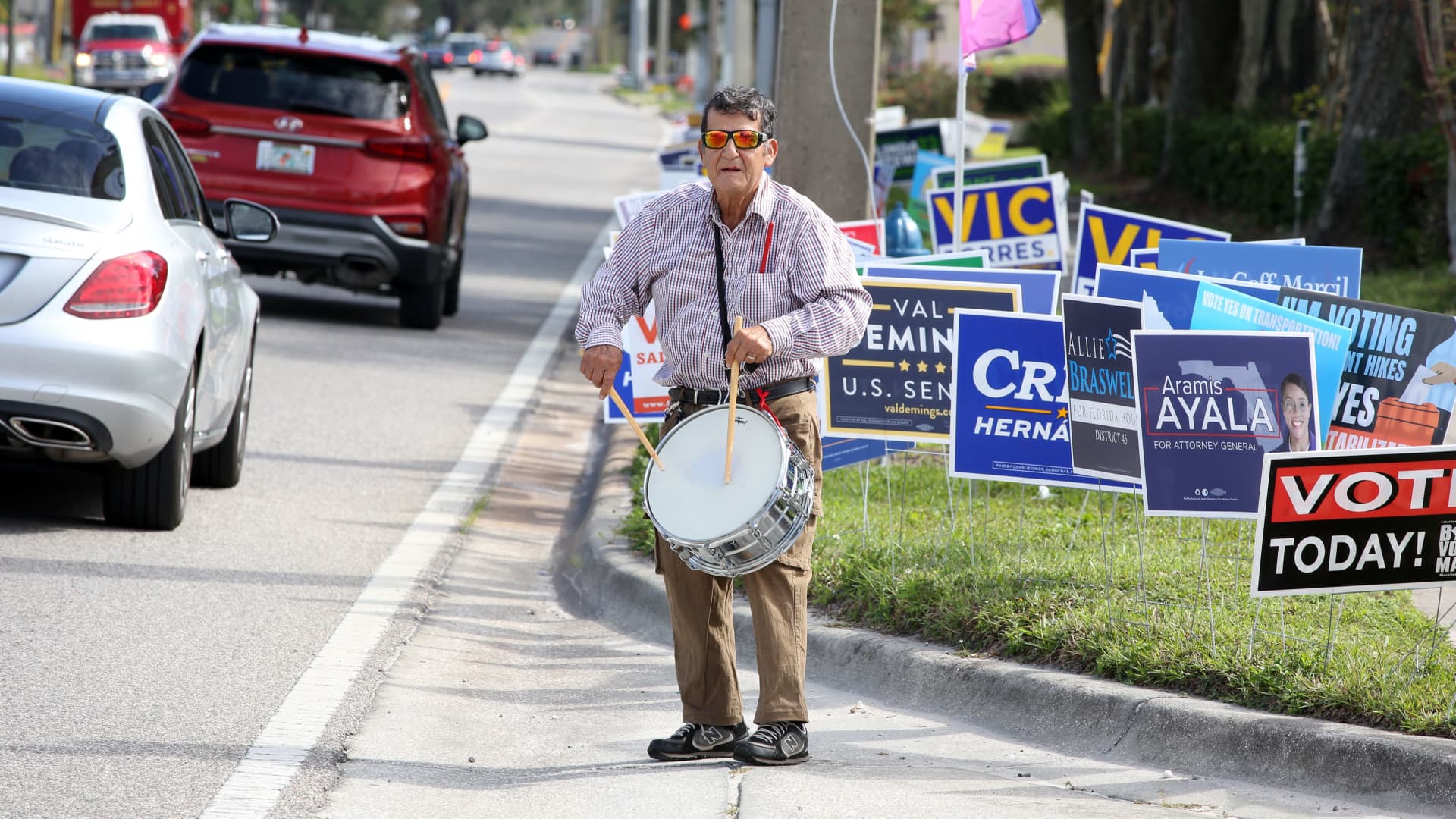 Eliot Letelier bangs on a drum, urging commuters to vote in the November 8 midterm elections in Orlando, Florida on November 7, 2022.