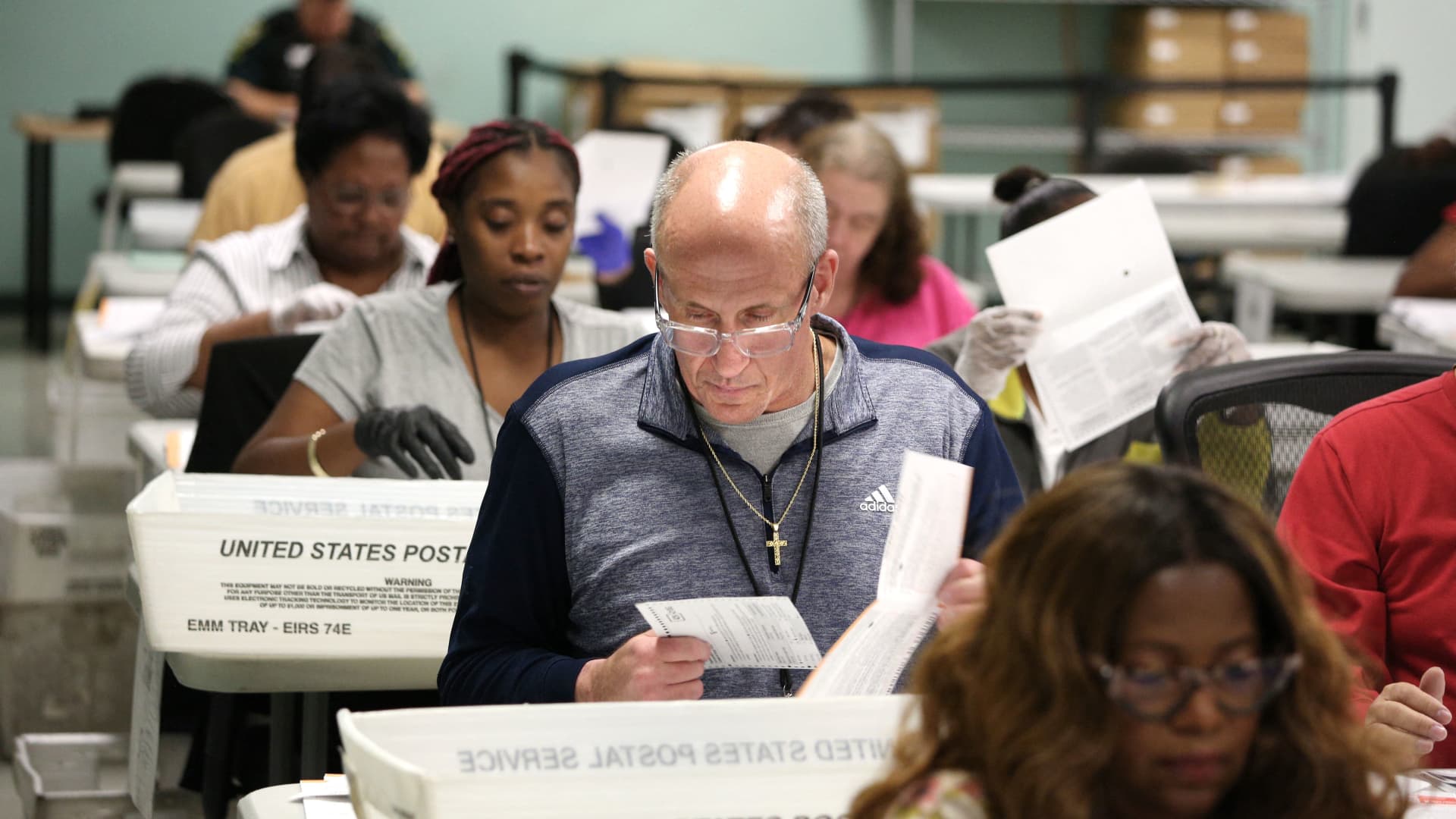 Election workers separate verified ballots from their envelopes at the Orange County Supervisor of Elections headquarters on the eve of the US midterm elections, in Orlando, Florida, on November 7, 2022.