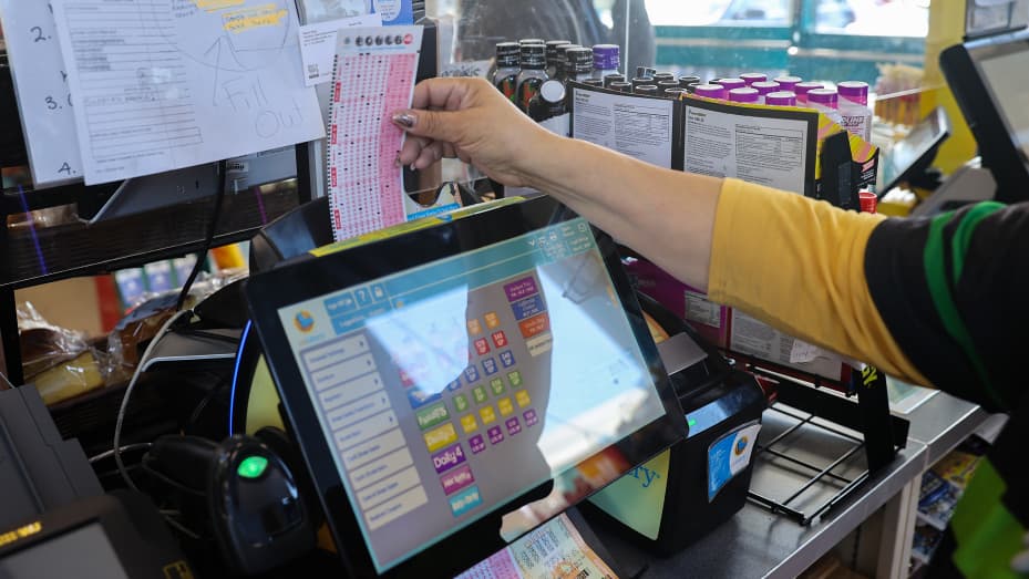 A cashier insert Powerball lottery tickets to the machine for a costumer at a 7-Eleven store in Milpitas, California.