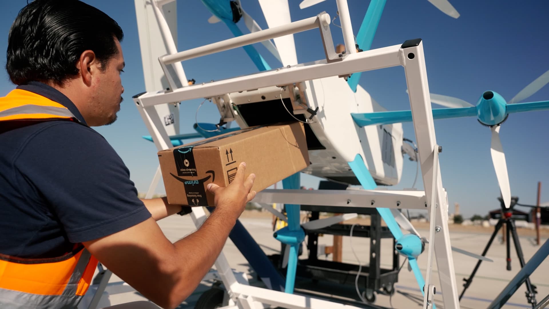 An Amazon drone operator loads the single shoebox-size box that can fit inside its MK27-2 Prime Air drone