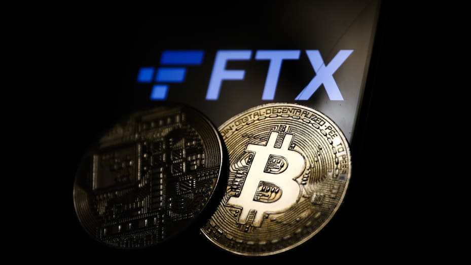 FTX logo displayed on a phone screen and representation of Bitcoin cryptocurrency are seen in this illustration photo taken in Krakow, Poland on November 14, 2022.
