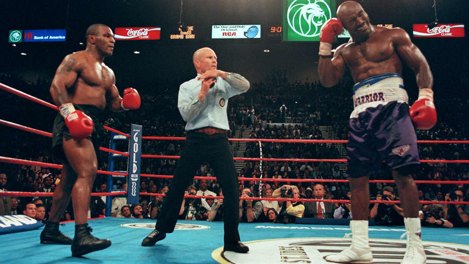 Referee Lane Mills (C) stops the fight in the third round as Evander Holyfield (R) holds his ear as Mike Tyson (L) watches 28 June 1997 during their WBA heavyweight championship fight at the MGM Grand Garden Arena in Las Vegas, NV.