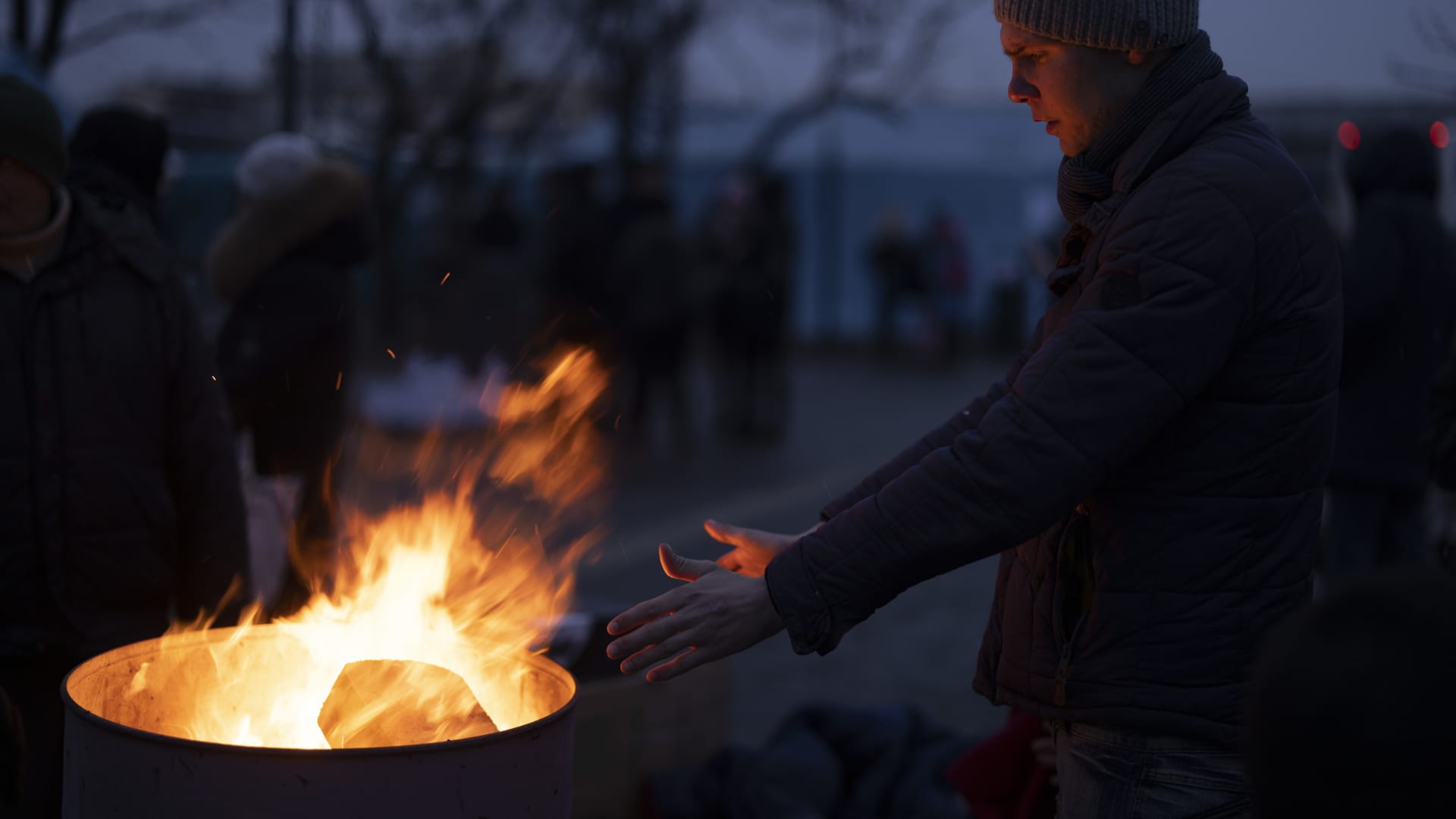 People keep warm by fires outside the main rail terminal in Lviv, Ukraine.