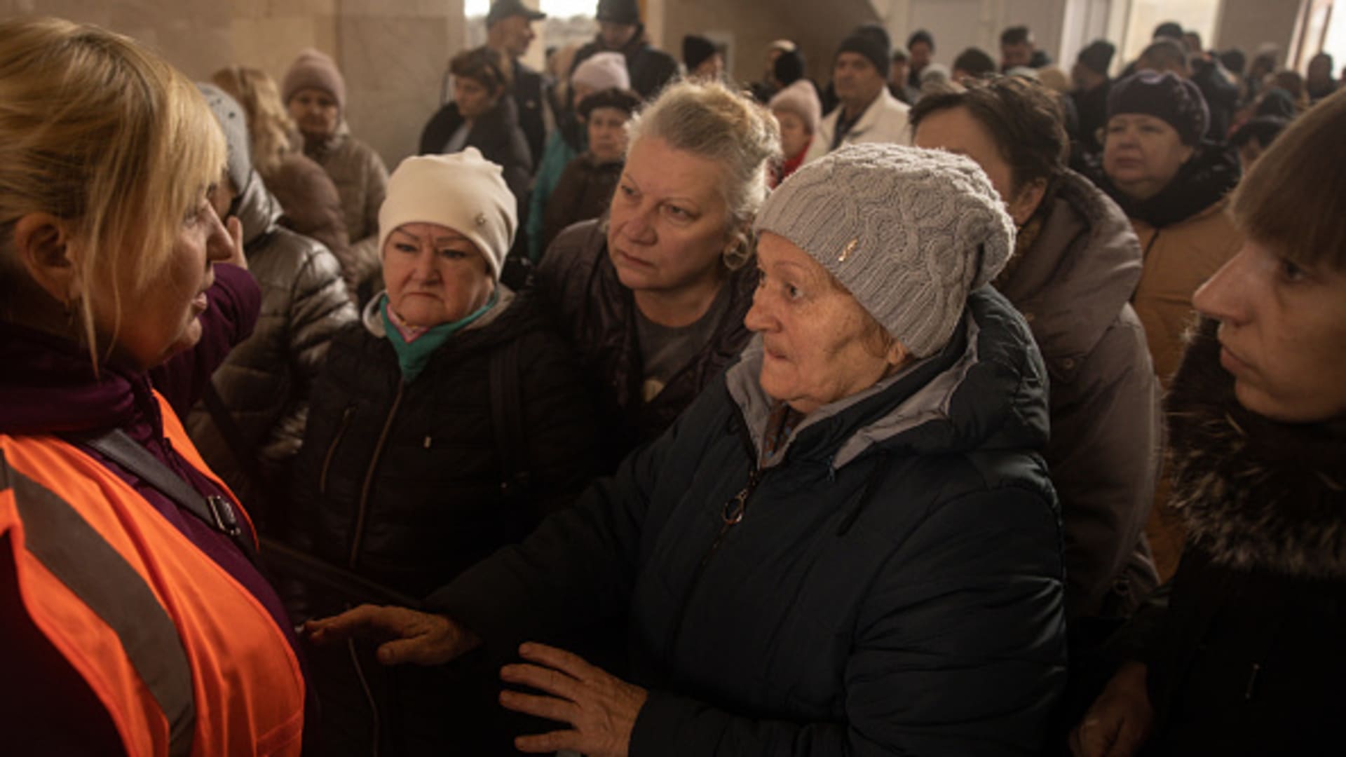 Residents talk with train station staff while waiting to be evacuated from Kherson on Nov. 21, 2022 in Kherson, Ukraine. The recently de-occupied city of Kherson is feeling power and water shortages acutely.