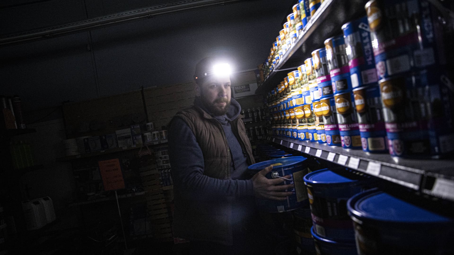 Oleg Bistrov, a Ukrainian salesman of a company that sells construction paint, works in the warehouse with a headlight during a power outage in Kyiv, Ukraine on November 21, 2022.