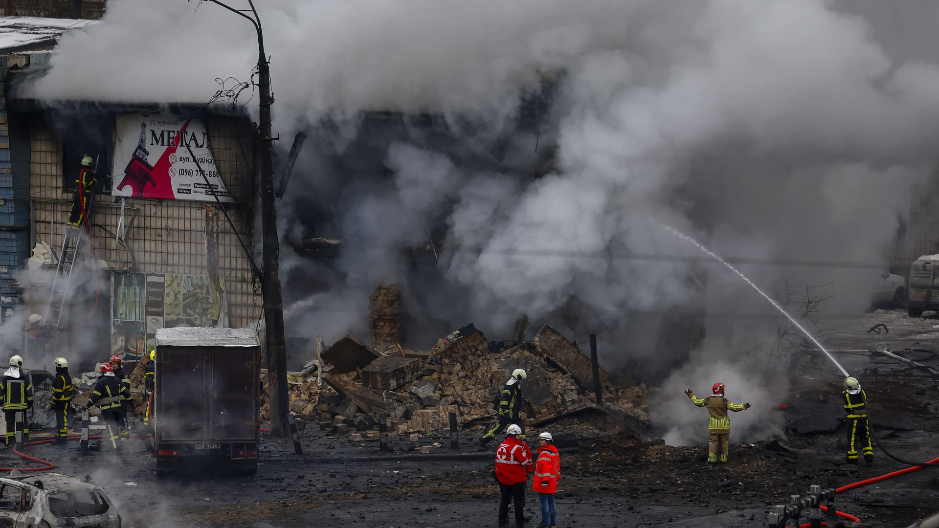 Fire and rescue workers attend a building hit by a missile in central Kyiv on November 23, 2022 in Kyiv, Ukraine.