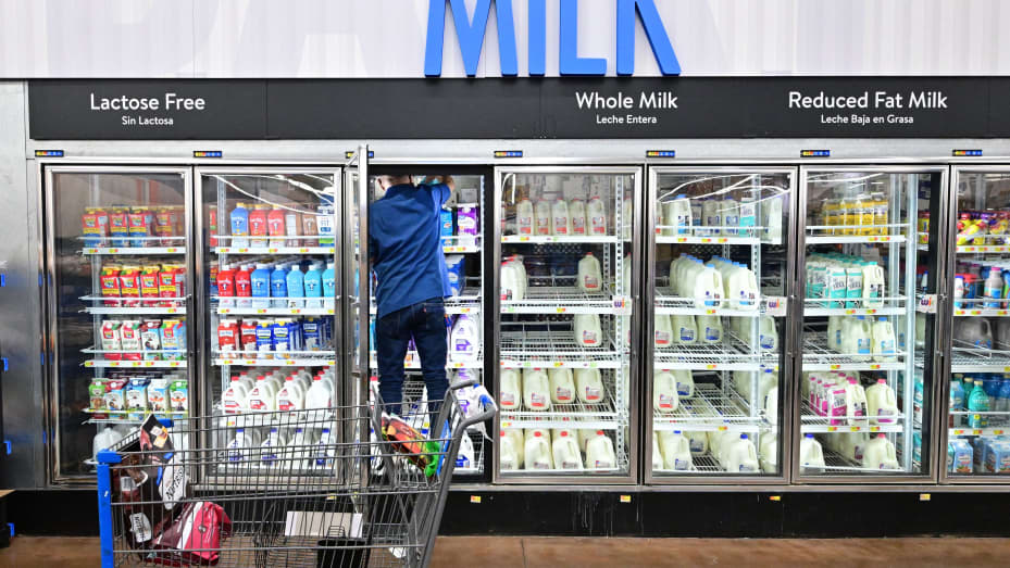 A man climbs into the fridge for milk at a Walmart store in Rosemead, California on November 22, 2022.