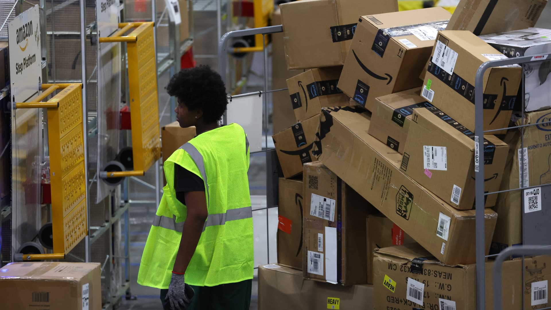 Amazon workers move carts filled with packages at an Amazon delivery station on November 28, 2022 in Alpharetta, Georgia. Amazon is offering deep discounts on popular products for Cyber Monday, its busiest shopping day of the year. 