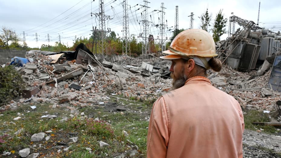 An employee of an energy company inspects an electrical transformer substation destroyed by Russian missile strikes on the outskirts of Kharkiv, Ukraine, on Oct. 4, 2022.