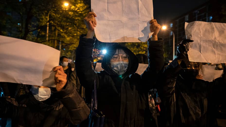 Protesters hold up a white piece of paper against censorship as they march during a protest against China's COVID-zero measures on November 27, 2022 in Beijing.