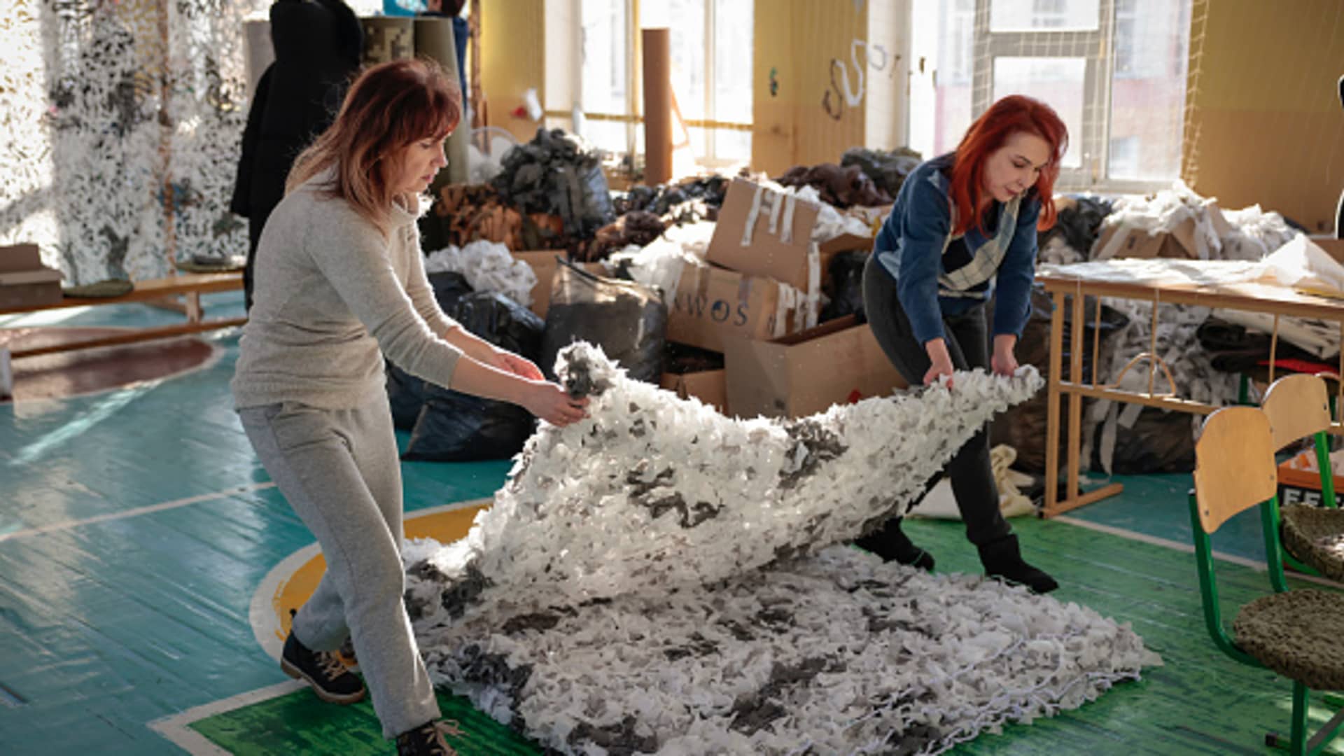 Women make artic warfare camouflage in a school gymnasium on December 01, 2022 in Bucha, Ukraine. Ukrainian officials expect a new wave of Russian bombing this week, with previous rounds targeting critical infrastructure and causing massive water and power cuts, including in the capital Kyiv. 