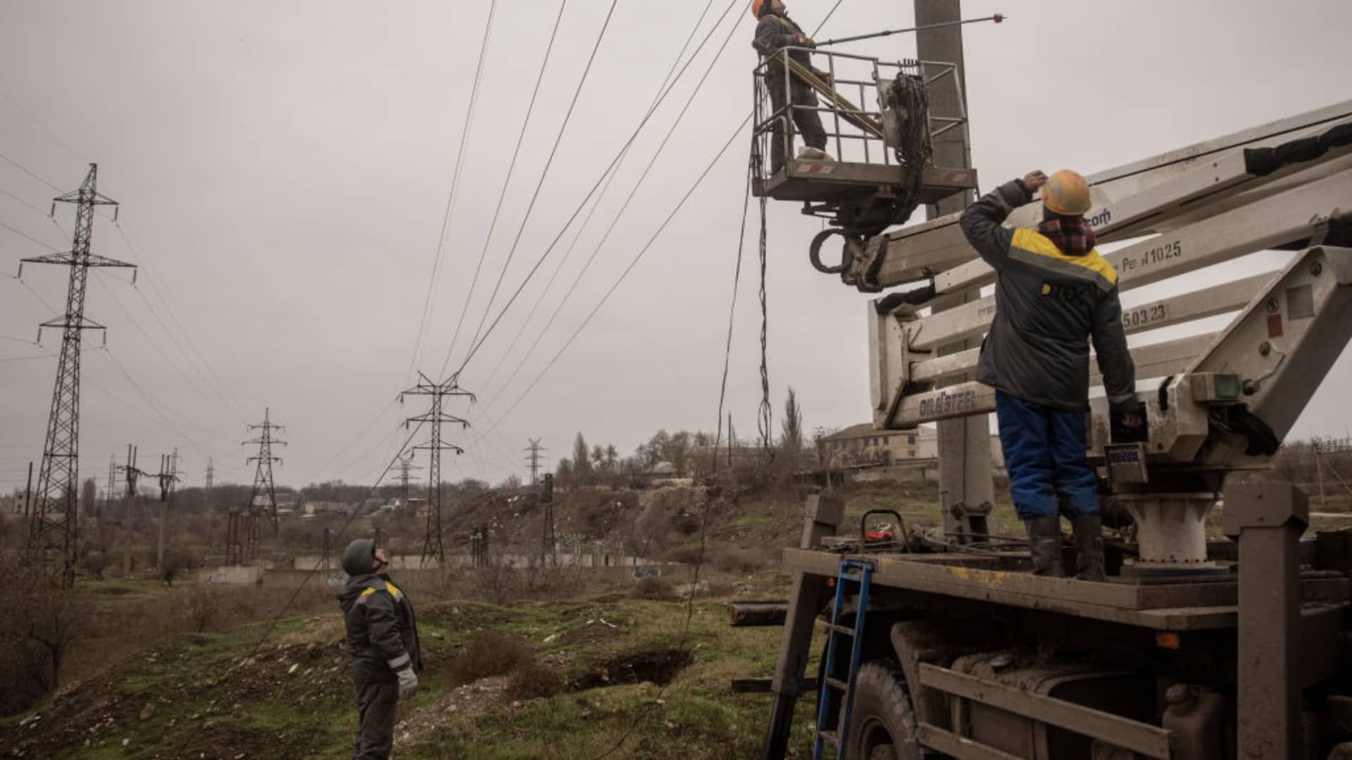Electricity workers from a team brought in from Odessa and wearing bulletproof vests and helmets prepare to start work to repair a destroyed high voltage power line on December 01, 2022 in Kherson, Ukraine. Teams of electrical workers have been brought in from across Ukraine to help restore power to Kherson City and surrounding areas. 