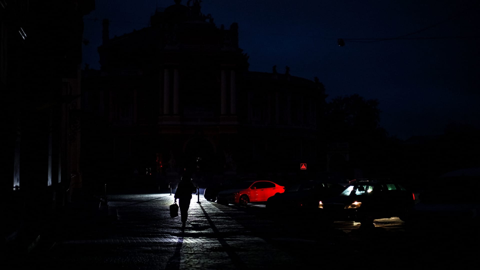 A pedestrian walks down a street during a power cut in downtown Odesa on December 5, 2022, amid the Russian invasion of Ukraine.