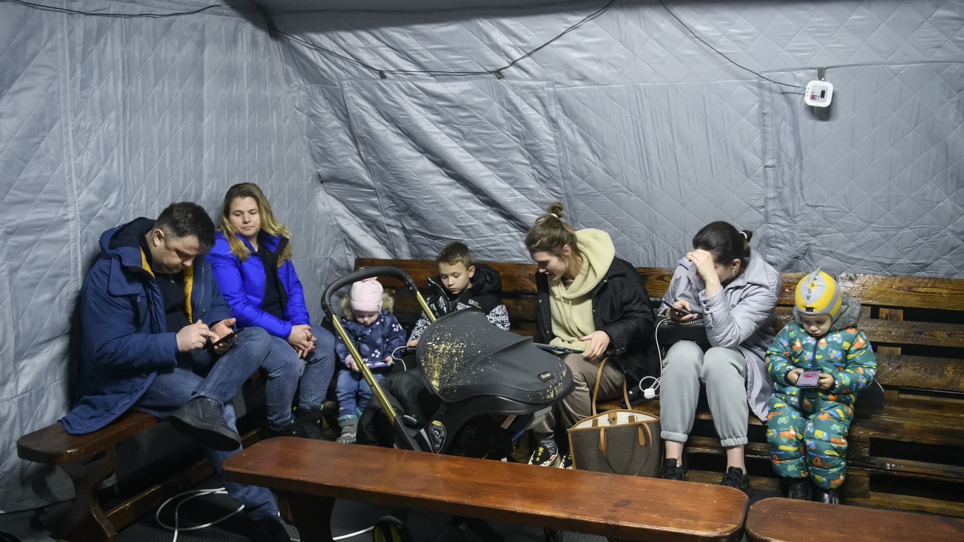 Local residents charge their devices, use internet connection and warm up after critical civil infrastructure was hit by Russian missile attacks in Kyiv, Ukraine, on Nov. 24, 2022.