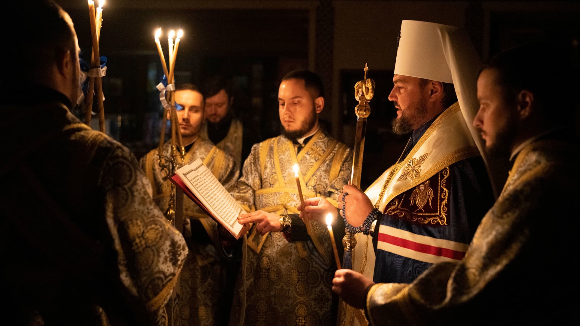 Metropolitan Oleksandr delivers a religious service with clerics inside the Transfiguration of Jesus Orthodox Cathedral during blackout caused by recent Russian rocket attacks, in Kyiv, Ukraine, Saturday, Dec. 3, 2022.