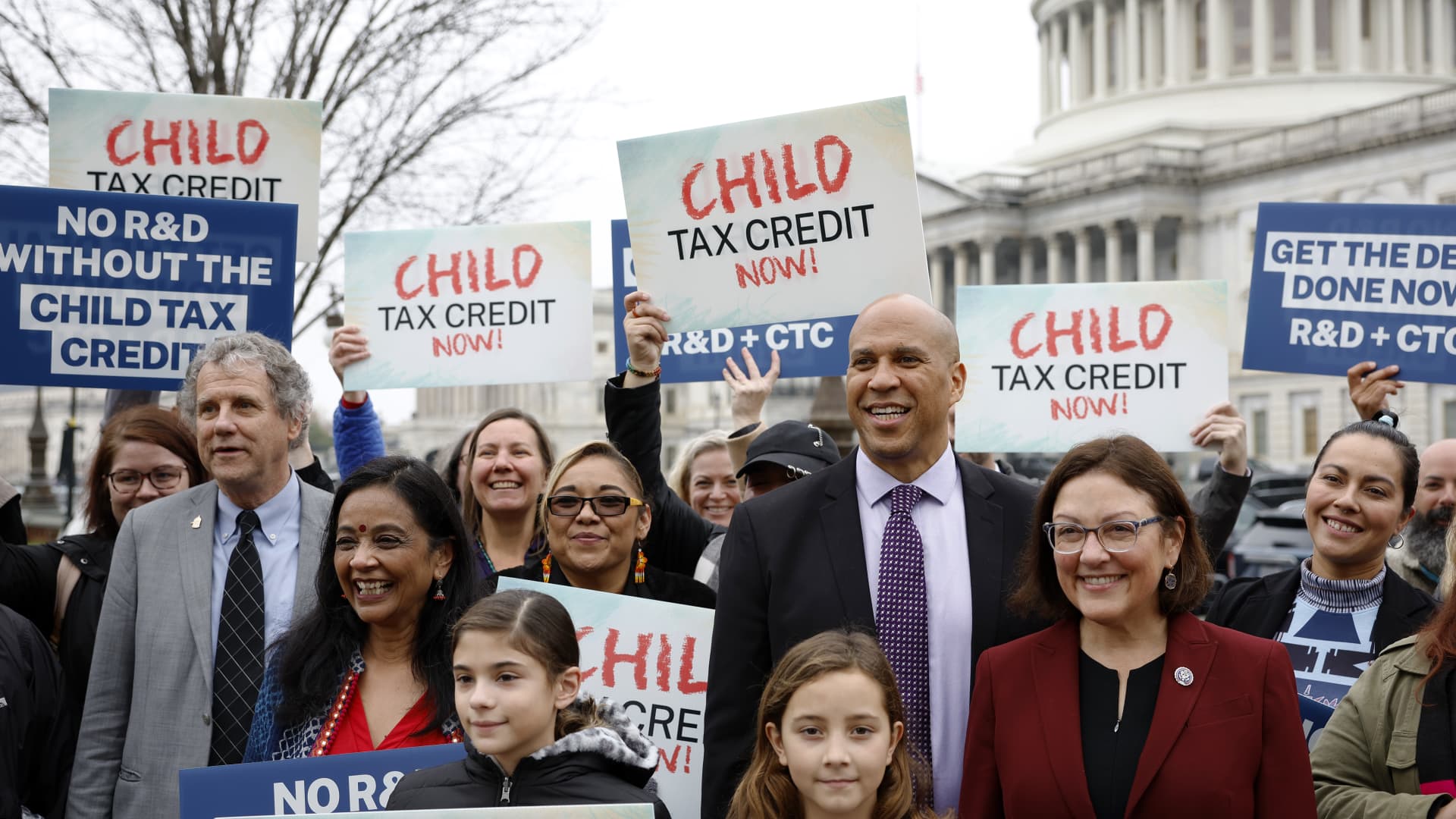 Senator Sherrod Brown, D-Ohio, Senator Cory Booker, D-N.J., and Rep. Suzan DelBene, D-Wash., with supporters during press briefing on expanding the child tax credit during the lame duck session on Dec. 7 in Washington, D.C.