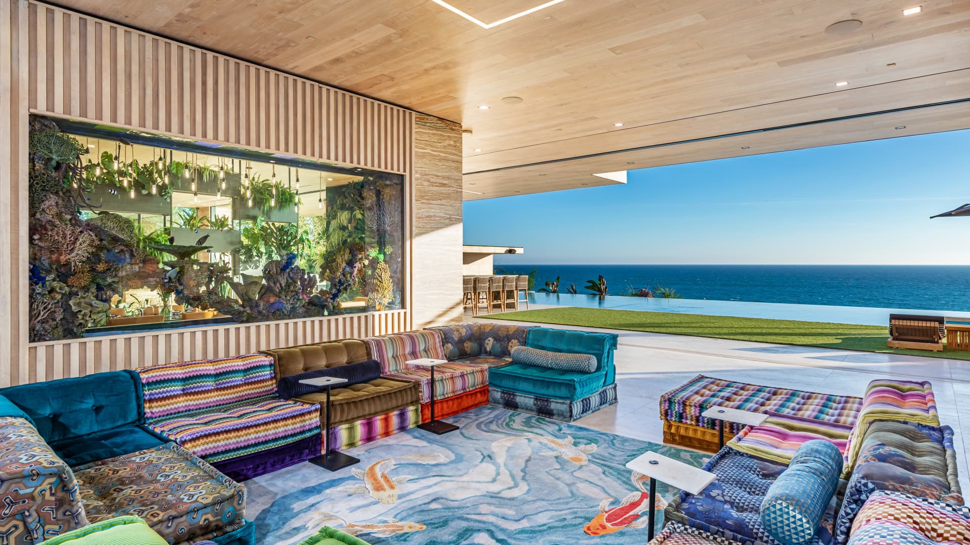 The brightly-colored living area has a trifecta of water views including the 2,000 gallon aquarium, infinity pool and Pacific Ocean.