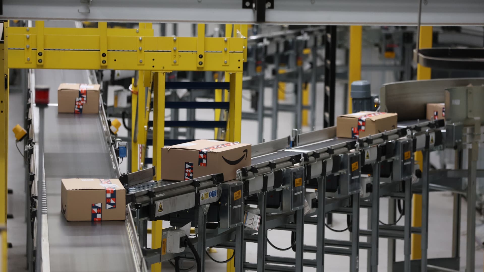 Amazon packages move on a conveyer belt at a fulfillment center in England.