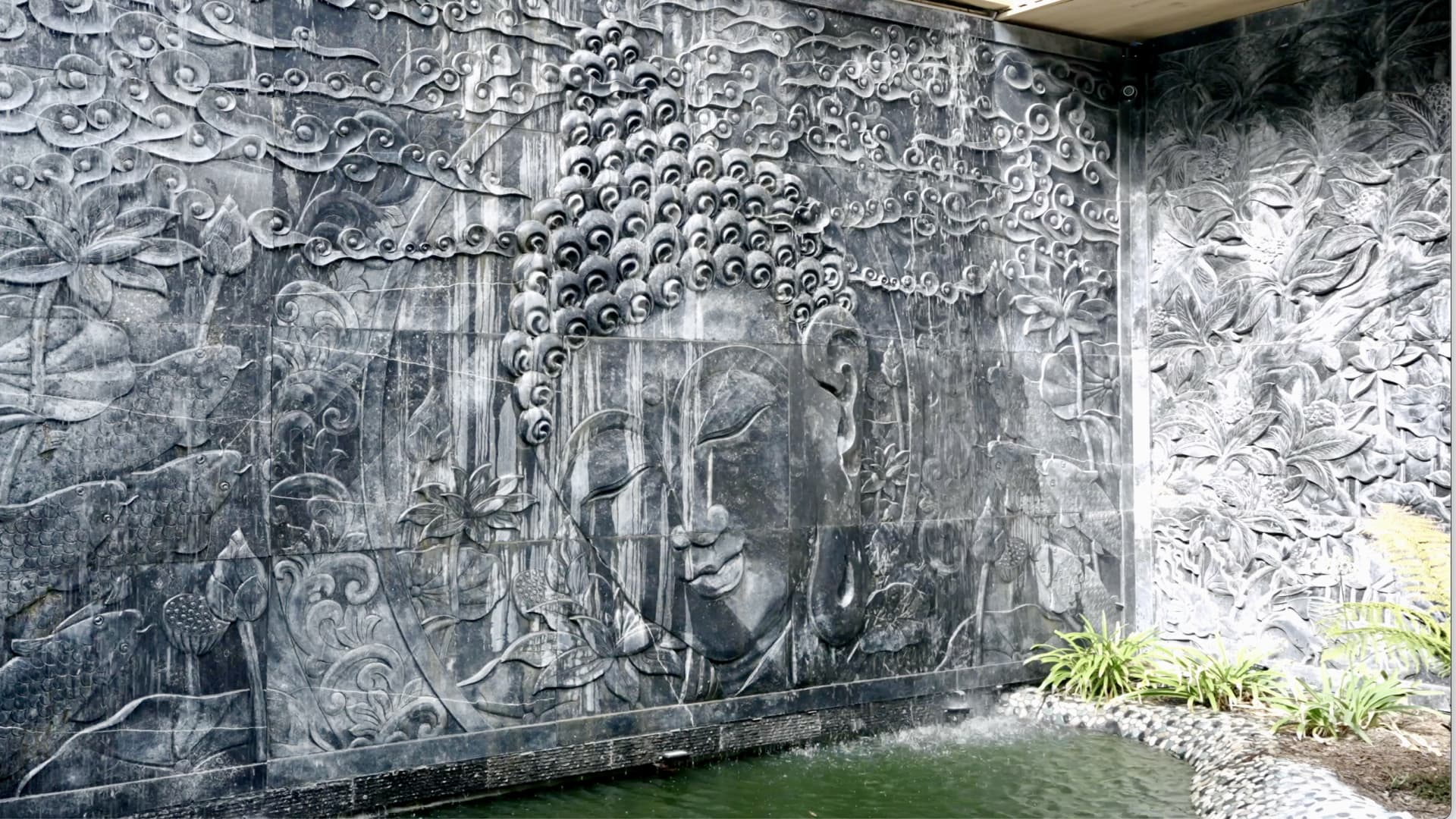 Water cascades down the courtyard's intricately carved Belgian bluestone wall into the koi pond.