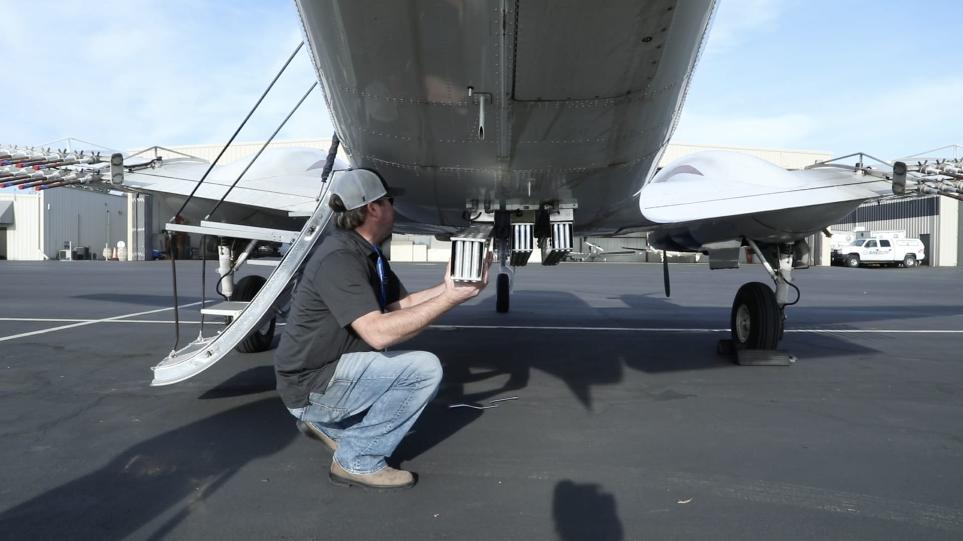 Pilot Joel Zimmer, who works for Weather Modification International, affixes silver iodide flares to the bottom of a cloud seeding plane.