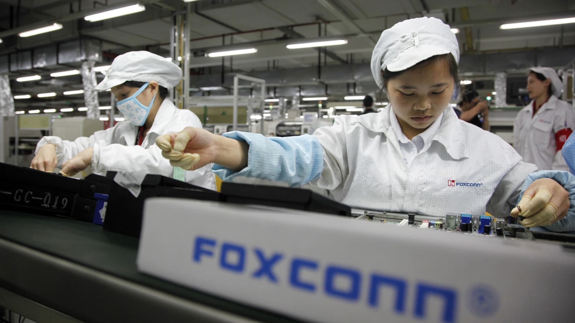 Employees work on the assembly line at Hon Hai Group's Foxconn plant in Shenzhen, China.