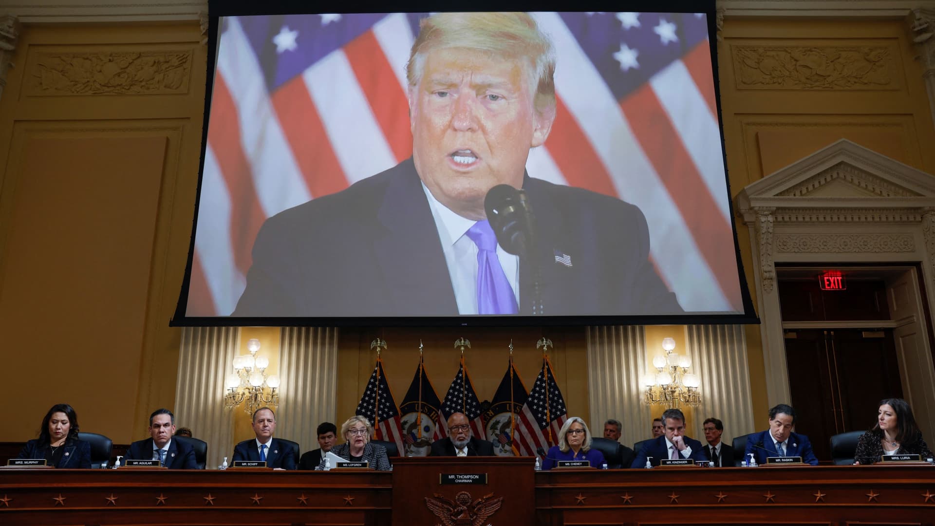 The members of the U.S. House Select Committee investigating the January 6 Attack on the U.S. Capitol sit beneath a video of former U.S. President Donald Trump talking about the results of the 2020 U.S. Presidential election as they hold their final public meeting to release their report on Capitol Hill in Washington, U.S., December 19, 2022. 