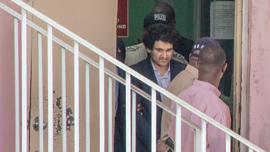 Sam Bankman-Fried is escorted out of the Magistrate's Court in Nassau