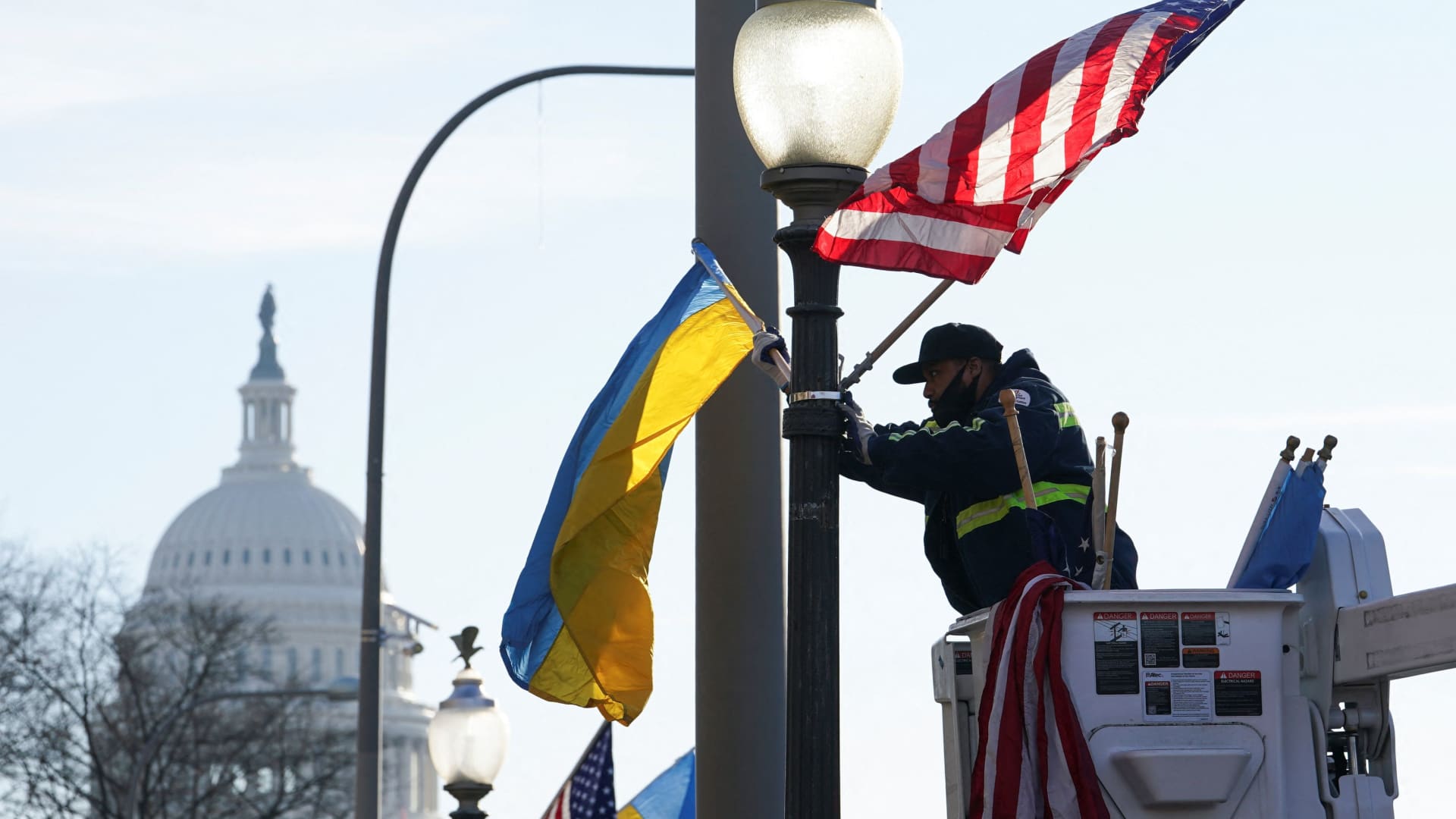 A worker installs Ukrainian and U.S. flags near the U.S. Capitol ahead of a visit by Ukraine's President Volodymyr Zelenskyy for talks with U.S. President Joe Biden and an address to a joint meeting of Congress in Washington, U.S., December 21, 2022. 