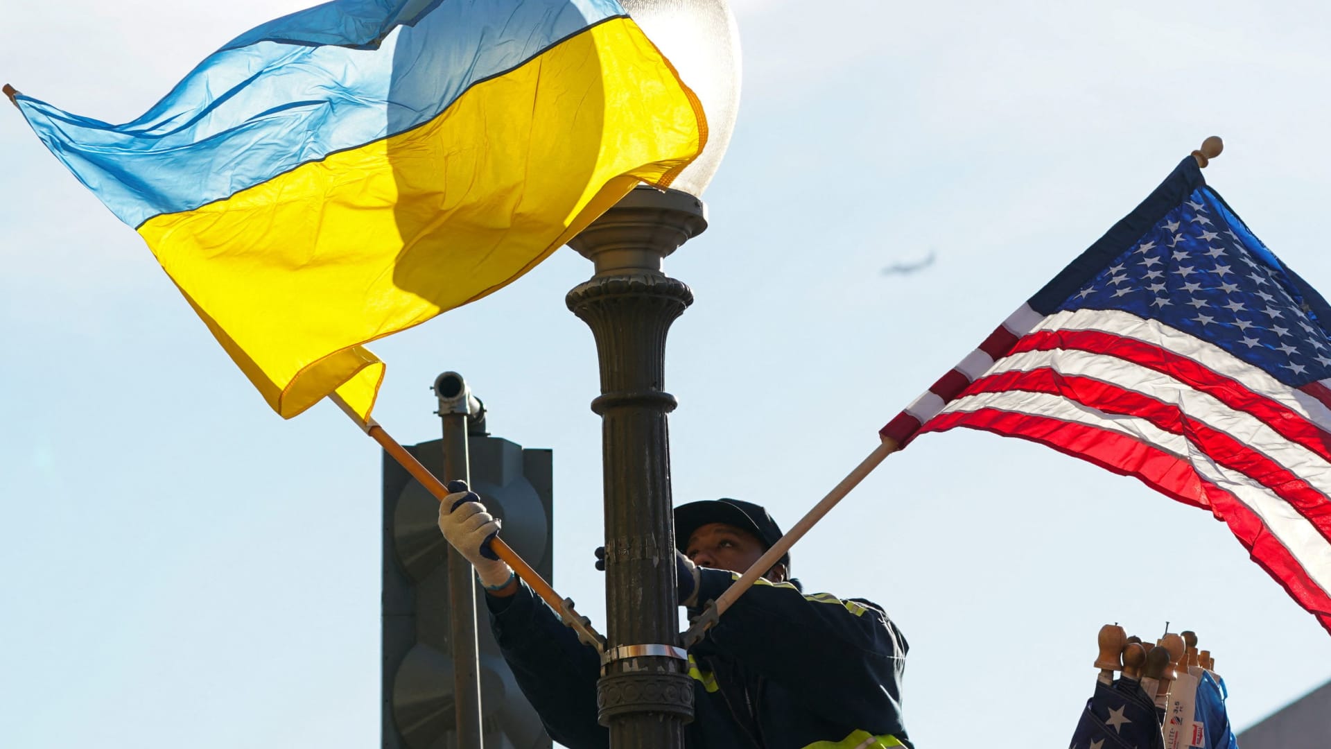 A worker installs Ukrainian and U.S. flags along Pennsylvania Avenue leading to the U.S. Capitol ahead of a visit by Ukraine's President Volodymyr Zelenskyy for talks with U.S. President Joe Biden and an address to a joint meeting of Congress in Washington, U.S., December 21, 2022. 