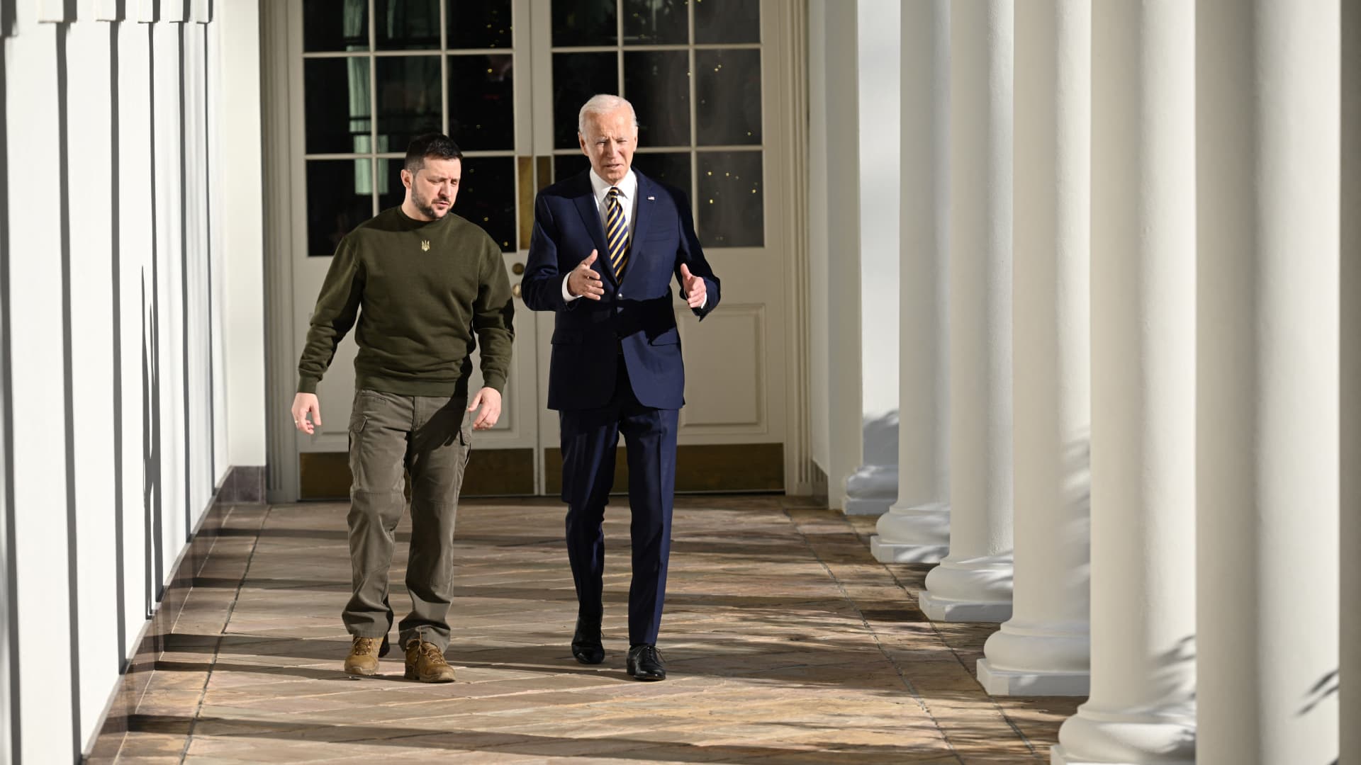 US President Joe Biden walks with Ukraine's President Volodymyr Zelensky through the colonnade of the White House, in Washington, DC on December 21, 2022.