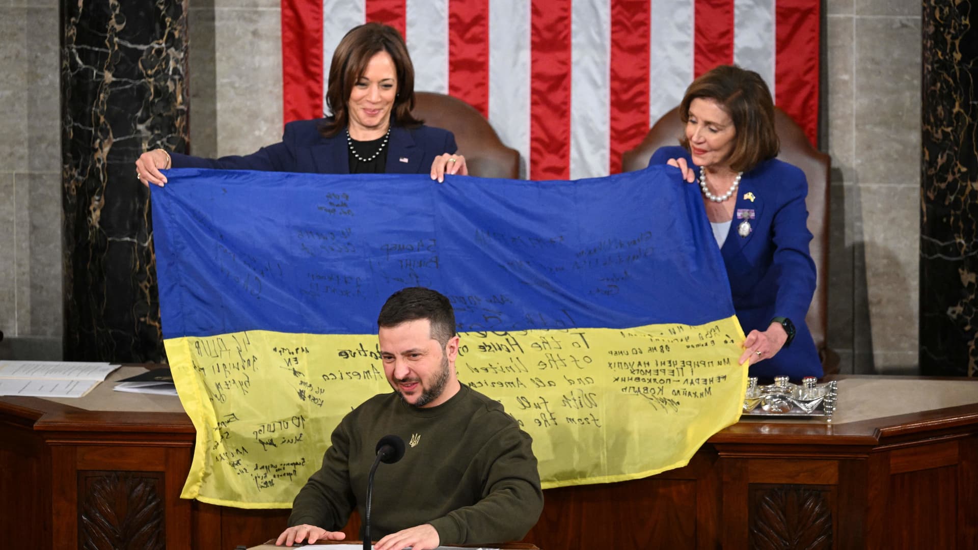 Ukraine's President Volodymyr Zelenskyy addresses the U.S. Congress as U.S. Vice President Kamala Harris (left) and U.S. House Speaker Nancy Pelosi (D-Calif.) hold a Ukrainian national flag at the U.S. Capitol in Washington, D.C. on Dec. 21, 2022.