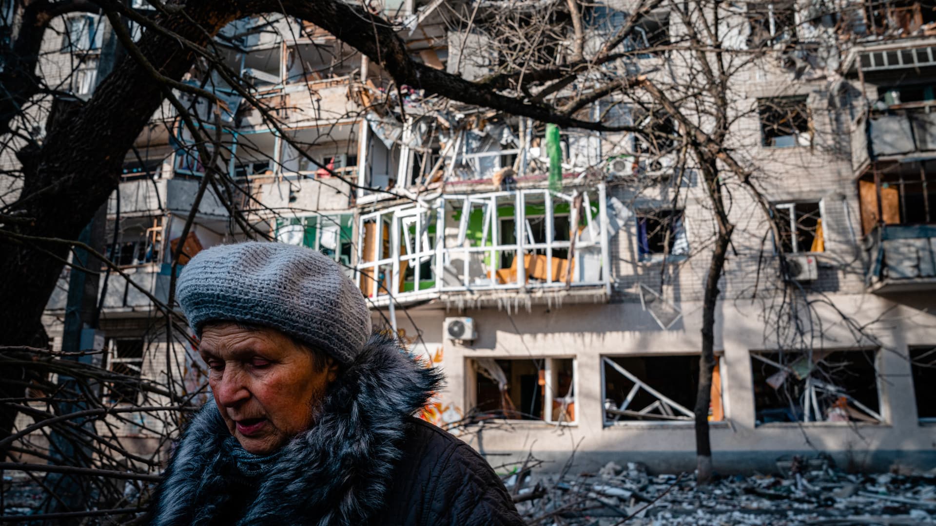 A pedestrian walks past a residential building damaged by Russian shelling in Kherson on December 20, 2022, amid the Russian invasion of Ukraine.