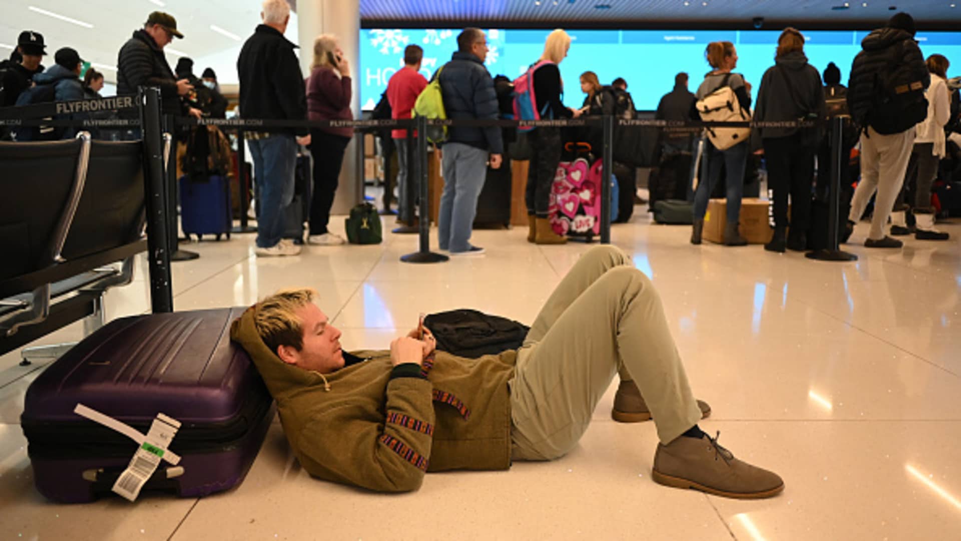 James Garofalo of Colorado Springs is checking cellphone after his flight cancelation at Denver International Airport in Denver, Colorado on Thursday, December 22, 2022.