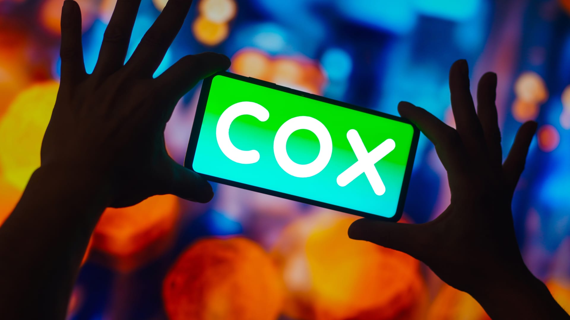 In this photo illustration, the Cox Communications logo is displayed on a smartphone screen.