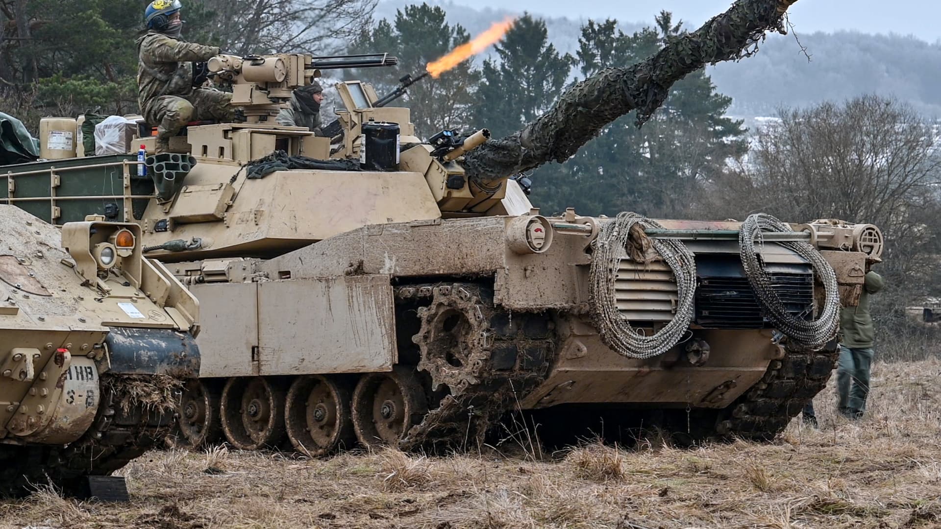U.S. soldiers fire from an M1 Abrams main battle tank.