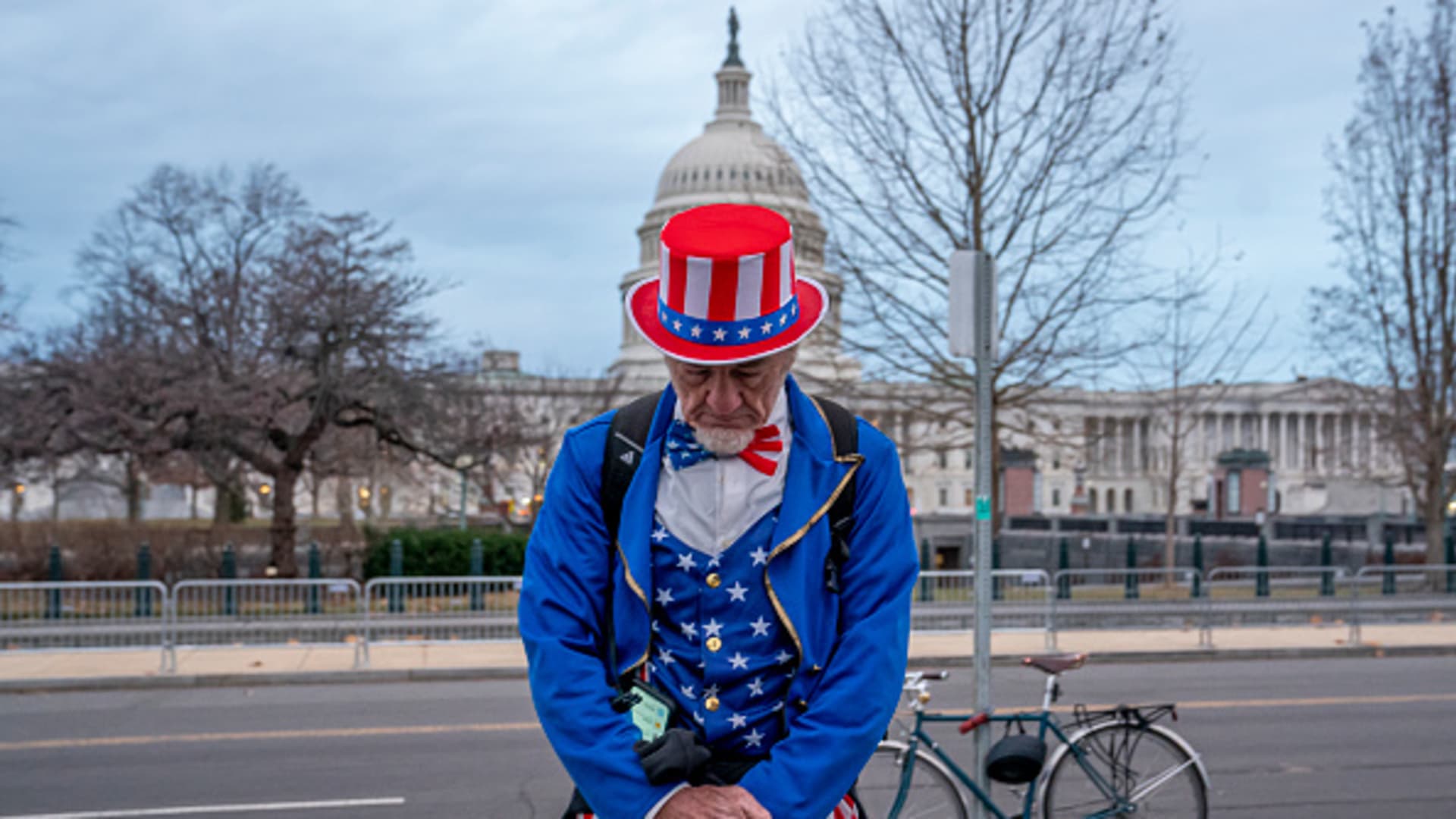 A man dressed as Uncle Sam, who's a regular attendee of events held by former President Donald Trump, stops to pray near community faith leaders during a vigil on the second anniversary of the January 6 attack on the Capitol on January 6, 2023 in Washington, DC.