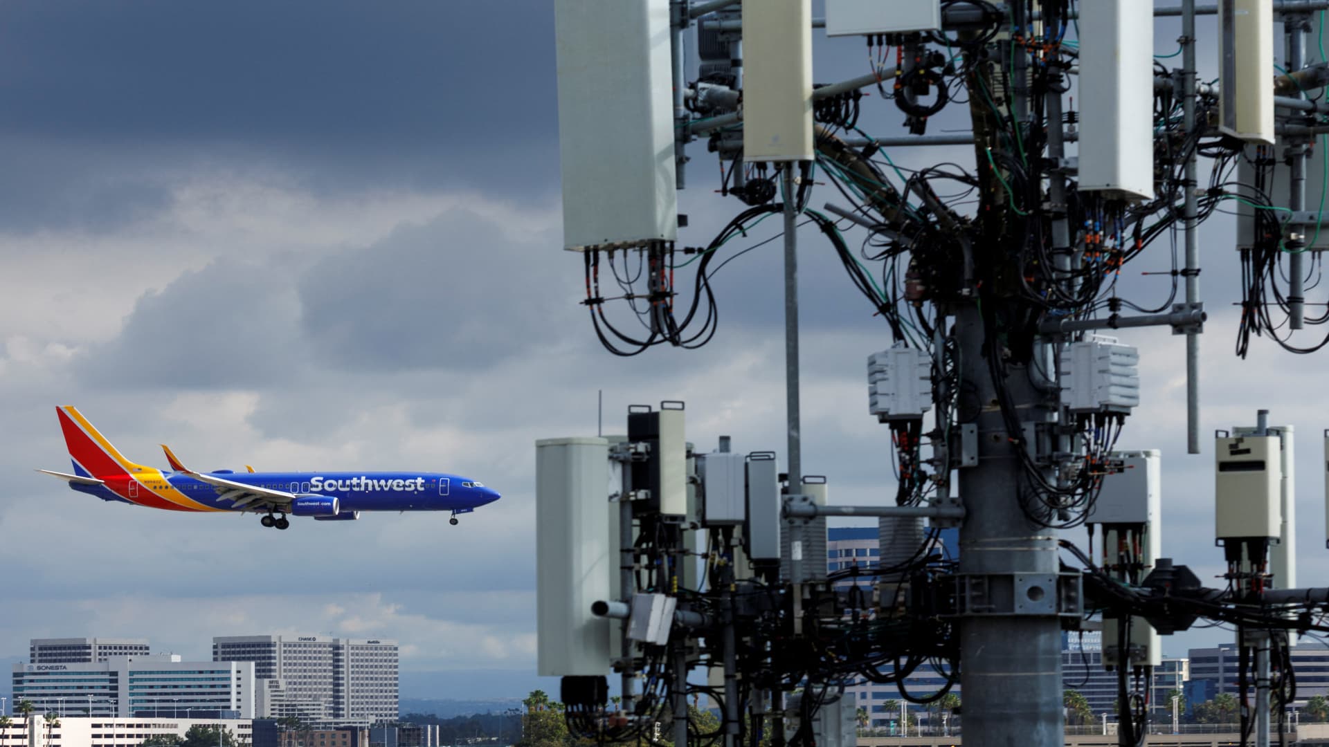 A Southwest commercial aircraft flies near a cell phone tower as it approaches to land at John Wayne Airport in Santa Ana, California U.S. January 18, 2022. U.S. airlines said on Wednesday the rollout of new 5G services was having only a minor impact on air travel as the U.S. Federal Aviation Administration (FAA) said it has issued new approvals to allow more low-visibility landings. 