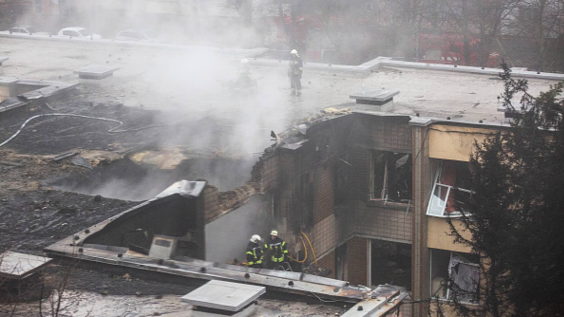 Firefighters work on the site where a helicopter crashed in Brovary, Kyiv.