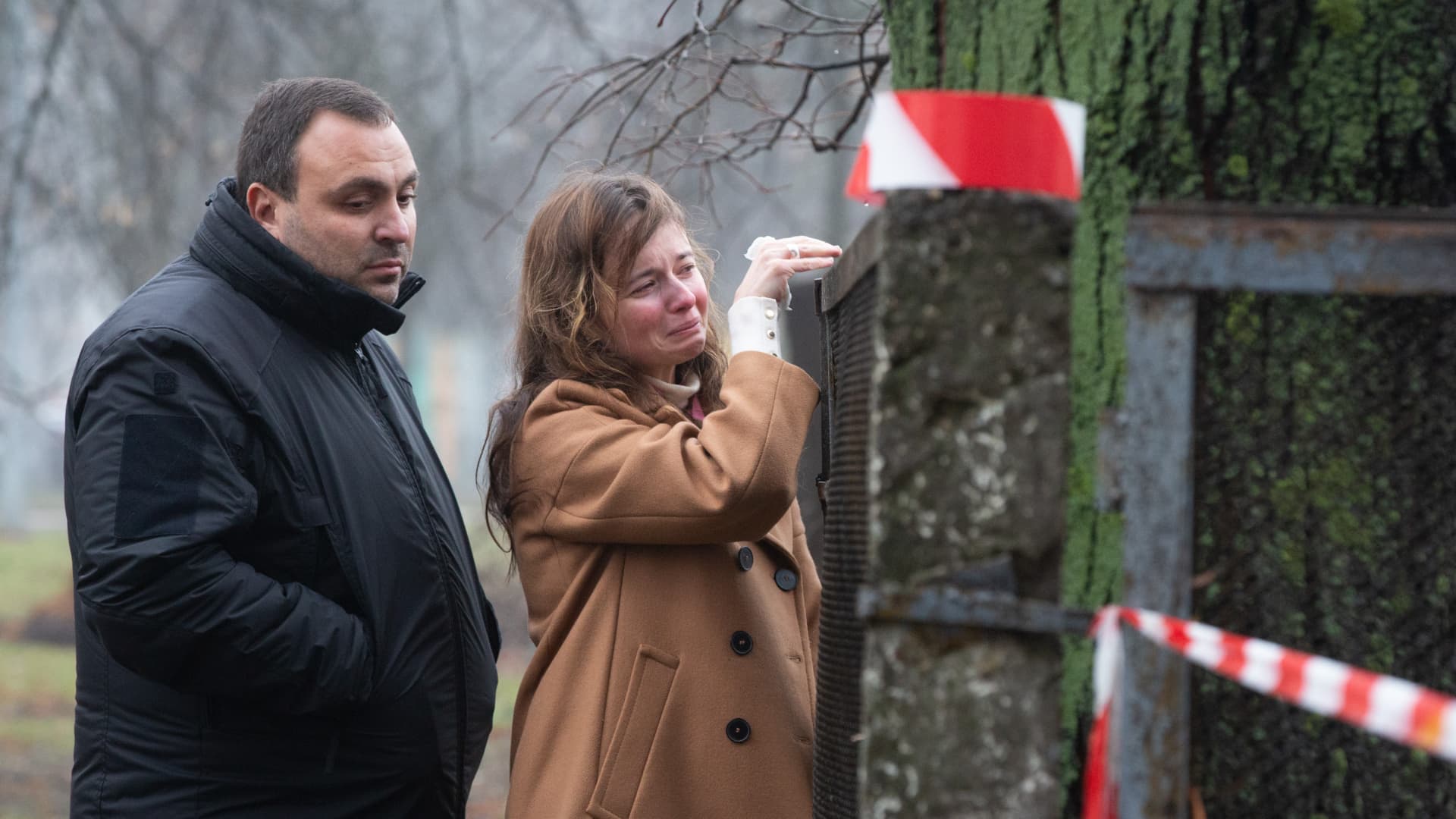 People mourn as police cordon off the site where a helicopter crashed in Brovary, Kyiv.